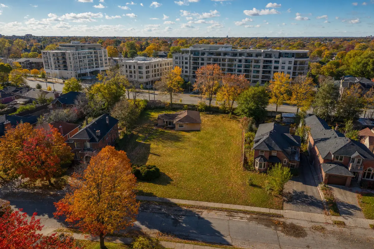 Aerial view of an underused residential lot with a bungalow among autumn maples